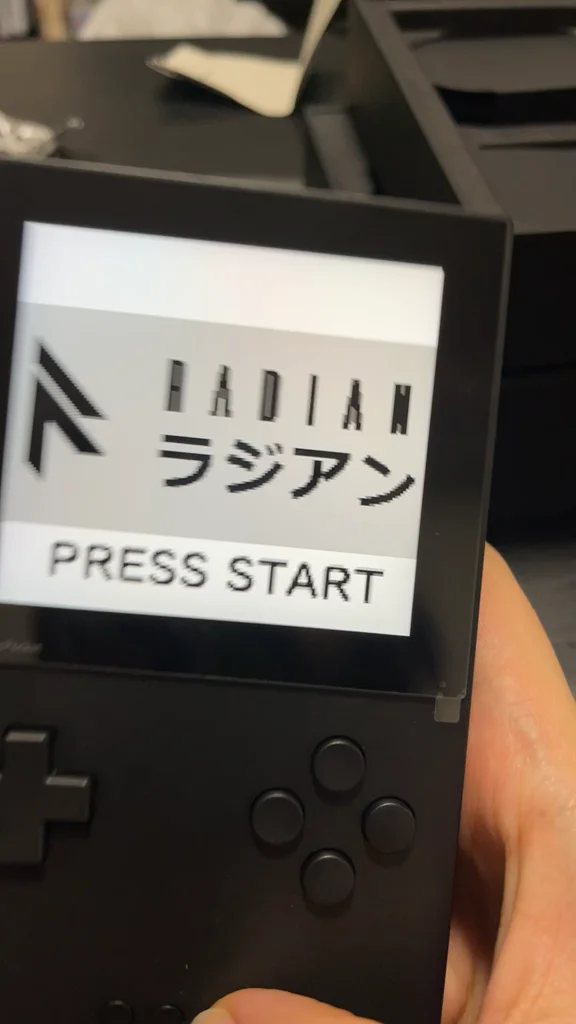 A handheld console showing the Radian title screen with Press Start